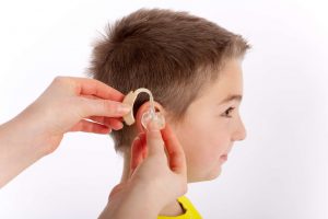 Therapist helping a child with speech problems related to hearing.