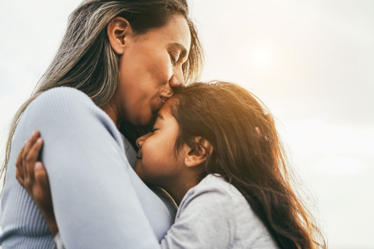 family-centered-speech-therapy-el-paso Mother hugging her daughter; family-centered pediatric speech therapy at New Beginnings El Paso
