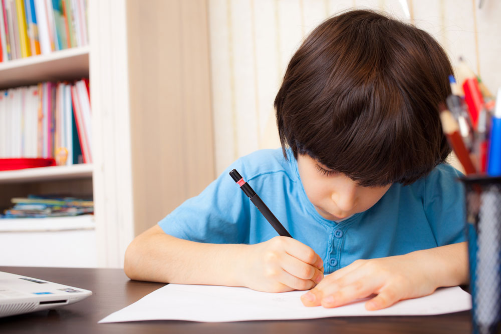 Boy practicing handwriting during pediatric occupational therapy in El Paso